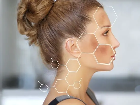 Una mujer sonriente de cabello castaño ondulado con una diadema roja de lunares y las manos en alto.