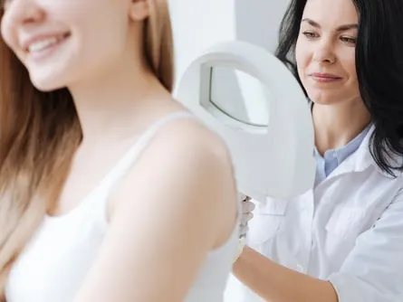 Dermatólogo concentrado usando lupa médica en la clínica