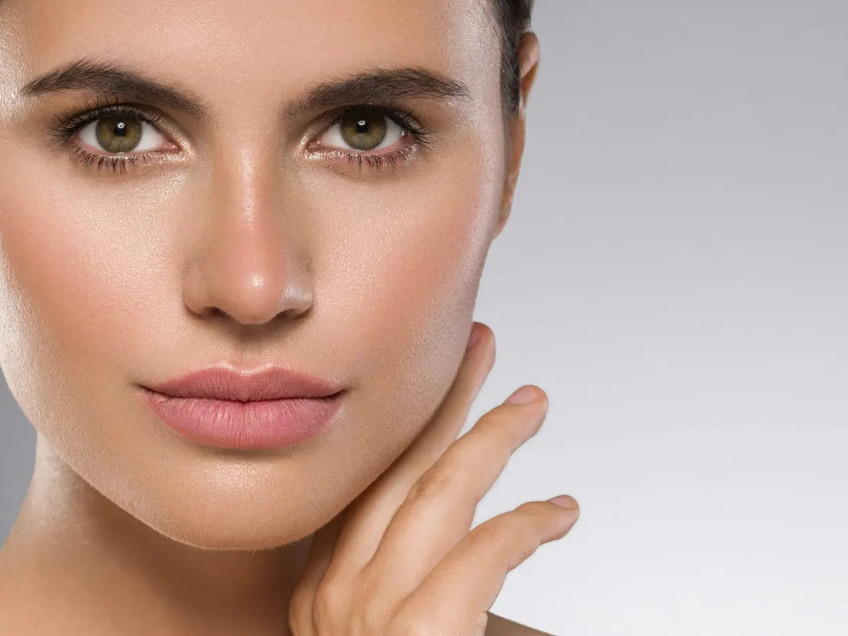 A woman showing her healthy skin from retinol treatment.