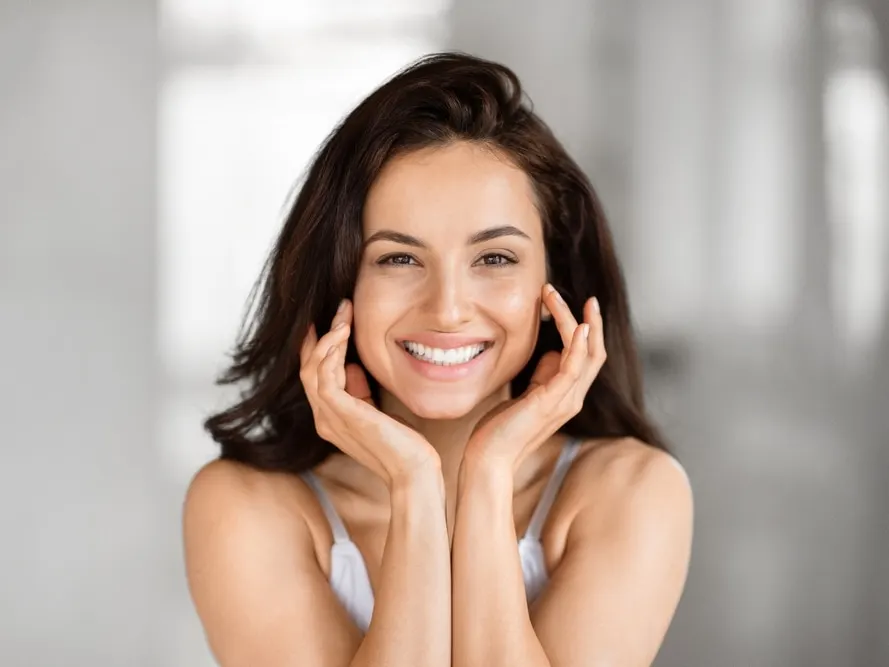 Smiling woman with beautiful glowing skin after cosmetic skin treatments.