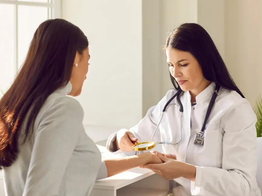 Female dermatologist inspecting skin of woman
