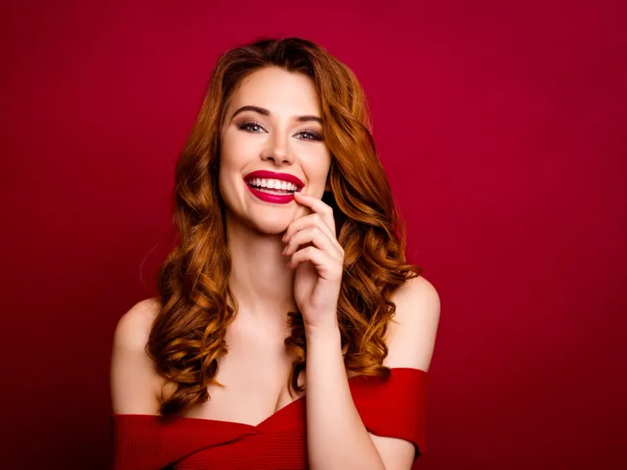 Woman smiling with red lips wearing red dress for valentine's day