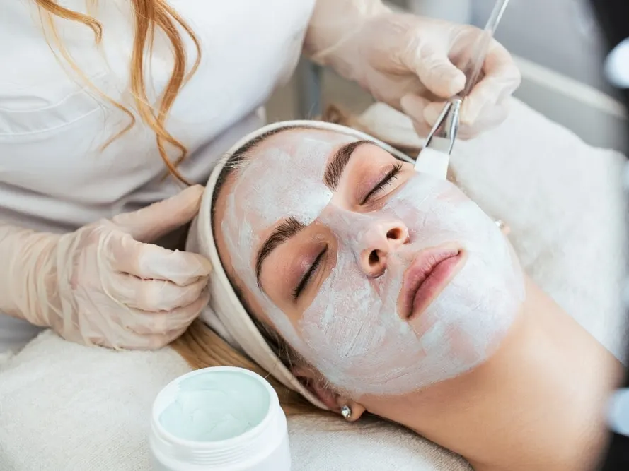 Woman getting facial treatment to reset skin after the holidays