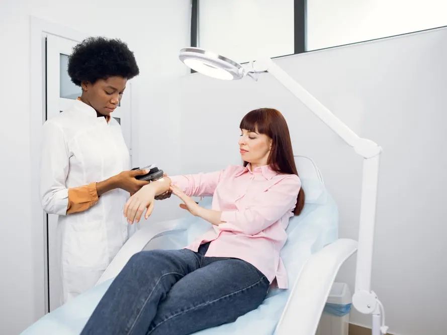 Dermatologist examining a woman's arm for skin conditions