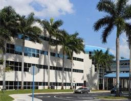 The Pembroke Pines office building, a white building with palm trees in front