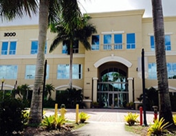 The entrance of the West Miramar office building, framed by palm trees