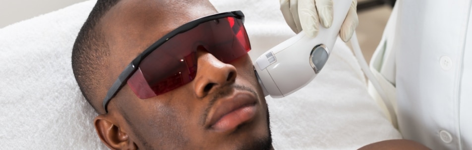 Un modelo con gafas protectoras recibe un tratamiento láser en la mandíbula
