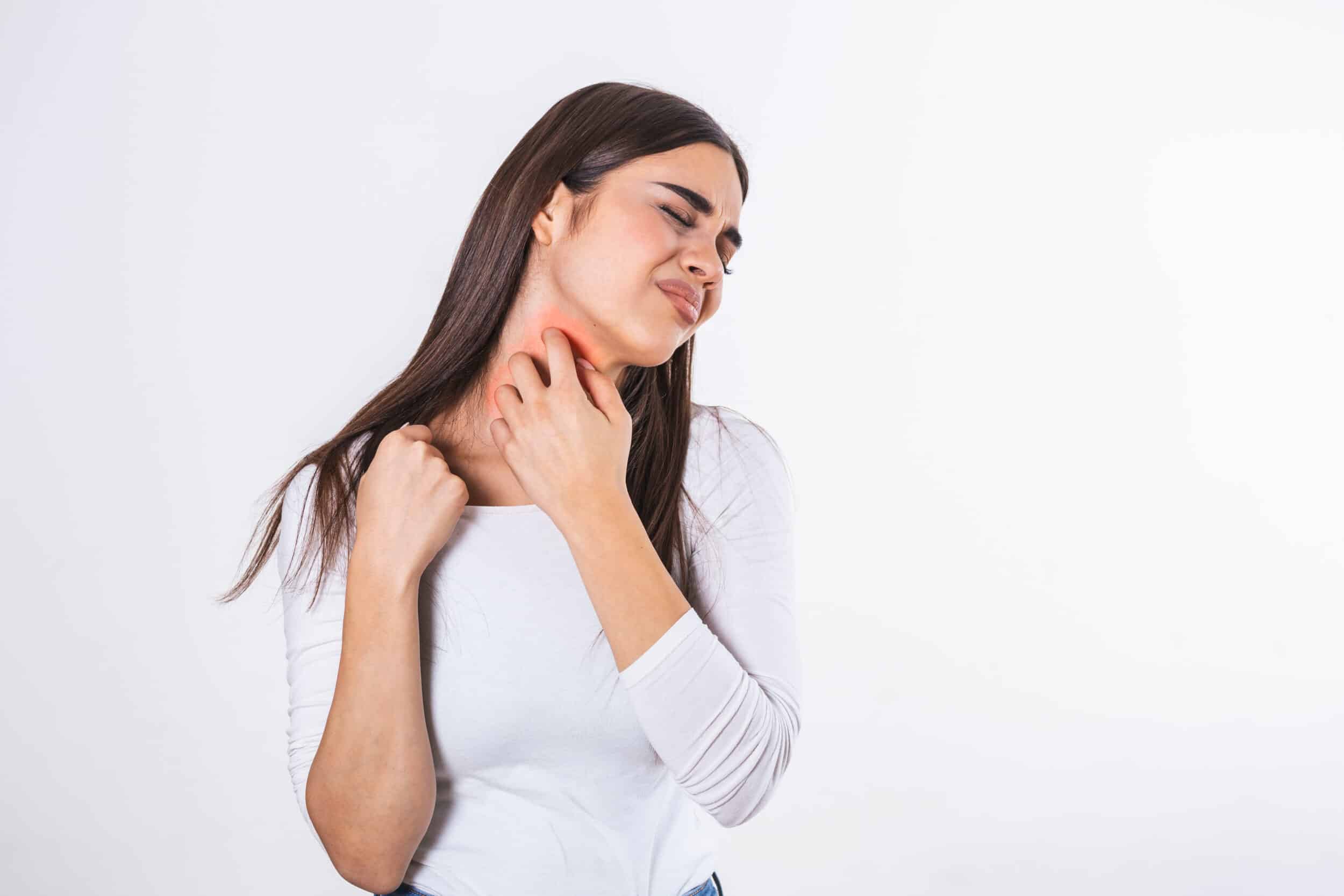 A woman scratching her neck because of a psoriasis flare-up