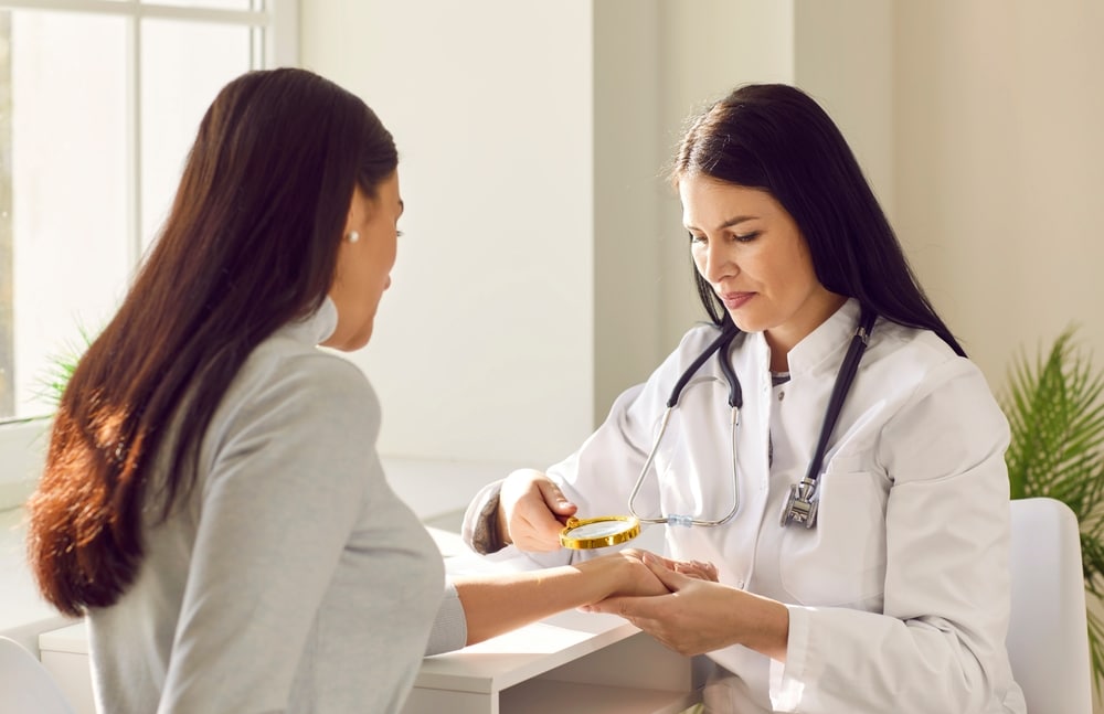 Female dermatologist inspecting skin of woman
