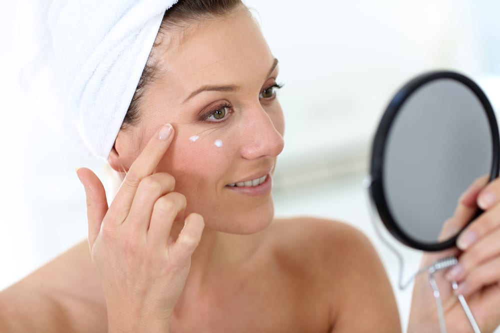 Woman doing her skincare routine in the morning and applying lotion