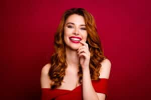 Woman smiling with red lips wearing red dress for valentine's day