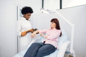 Dermatologist examining a woman's arm for skin conditions
