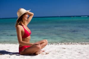 Woman in the sun with a hat to protect from hyperpigmentation in Broward County, FL